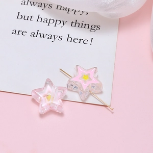 Detailed view of clear acrylic star beads with pink and yellow inner star for DIY jewelry