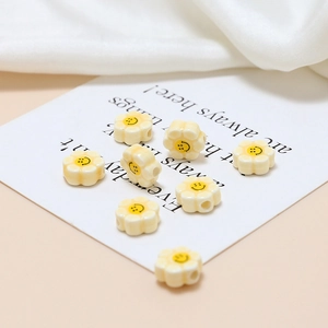 Macro view of cream floral ceramic beads with smiley face pattern for DIY jewelry making