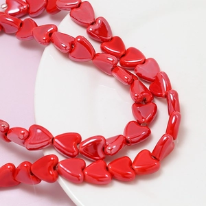 Close-up of vibrant red ceramic heart beads with high gloss finish for DIY jewelry
