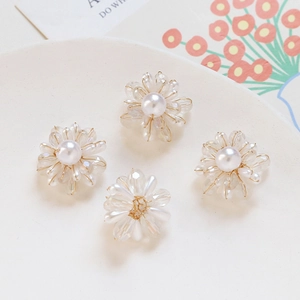 Détail macro de quatre écussons de fleurs en perles de cristal pour la bijouterie