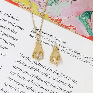 Gros plan d'un pendentif main plaqué or avec zircon cœur sur une page de livre d'art