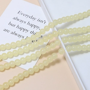 Close-up of 8mm cream-yellow jelly glass beads with smooth luster for DIY jewelry