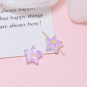 Macro view of purple star-shaped resin beads with yellow inner stars for DIY jewelry