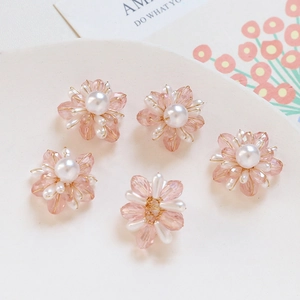 Vue détaillée de cinq pendentifs fleurs faits main en cristal et perles sur un plateau