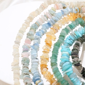 Various natural tumbled stone beads for jewelry making displayed on a white tray