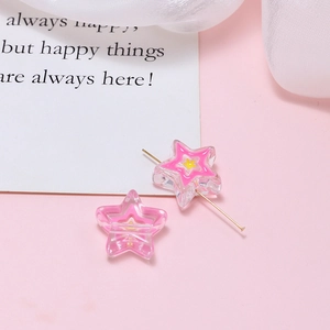 Macro detail of star-shaped acrylic beads with pink and yellow inner patterns for DIY crafts