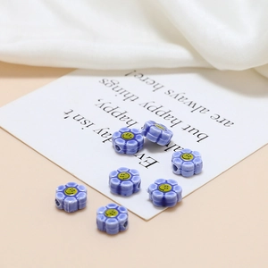 Macro detail of lilac ceramic flower beads with smiling face for DIY jewelry making
