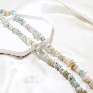 Detail view of colorful irregular natural crystal stone beads on a white tray