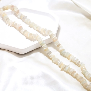 Detailed macro view of natural milky white crystal chip beads with pearlescent luster