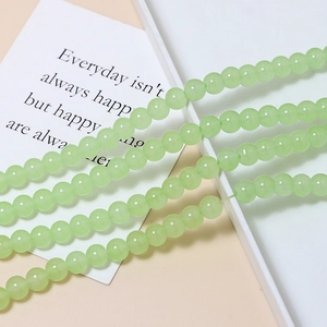 Close-up of 8mm light green macaron glass beads for DIY jewelry making and handmade crafts