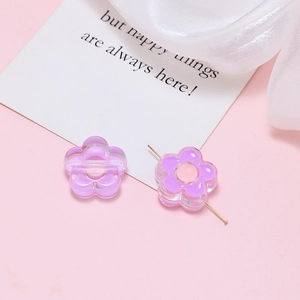 Detailed view of two purple acrylic flower beads with pre-drilled holes for DIY jewelry