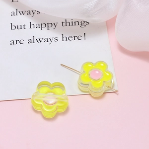 Detailed macro view of yellow acrylic flower beads with center holes for DIY jewelry
