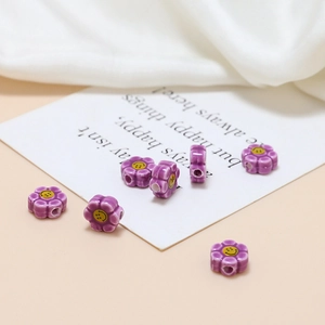 Macro detail of purple flower ceramic beads with yellow smiley face for DIY jewelry making