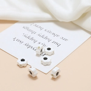 Macro detail of smiley face ceramic flower beads for DIY jewelry making on card