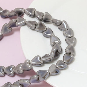 Macro detail of glossy grayish-purple heart ceramic beads for DIY jewelry making