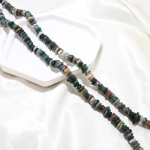 Macro detail of natural irregular gemstone beads with textured agate on silk background