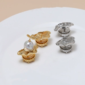 Bases de broche de hoja de loto en oro y plata con perlas barrocas en plato blanco
