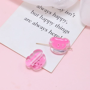 Close-up of pink resin bear beads with drill holes for DIY jewelry making accessories