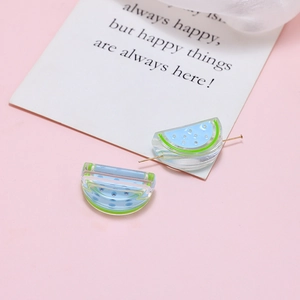 Macro detail of acrylic watermelon charms with holes for DIY jewelry making kits