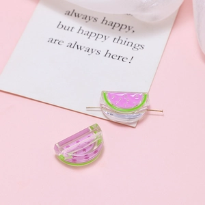 Macro detail of acrylic watermelon charms for DIY jewelry making with sparkly purple centers