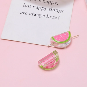 Macro detail of acrylic watermelon charms with glossy resin finish for DIY jewelry