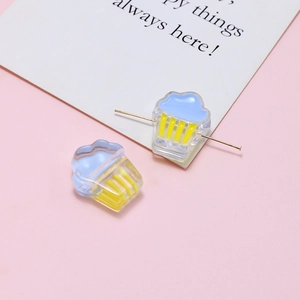 Detail of cupcake-shaped resin beads in blue and yellow for DIY jewelry making crafts