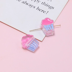 Macro view of pink and blue acrylic cupcake beads for DIY jewelry with metal pin detail