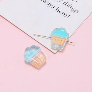 Macro view of blue and orange cupcake resin beads with metal pins for DIY jewelry making