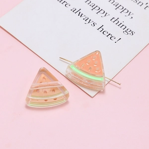 Macro detail of translucent acrylic watermelon charms for DIY jewelry making and earrings
