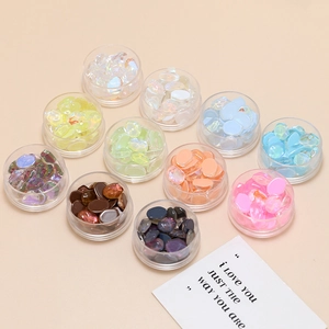 Macro view of colorful crystal glass charms in round boxes for DIY nail art and jewelry