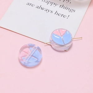 Detailed view of clear acrylic beads with pink and blue peace signs for DIY crafts