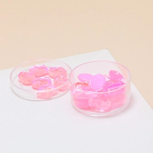 Close-up of translucent pink jelly crystal stones in clear trays for DIY jewelry making