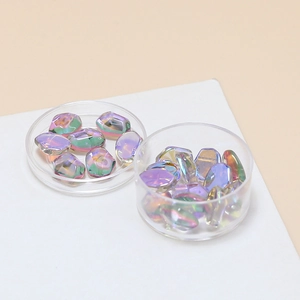 Close-up of iridescent aurora glass beads in clear plastic cases for DIY jewelry crafting