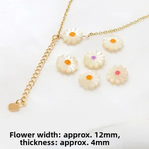 Macro detail of natural mother-of-pearl daisy pendants with golden chain for DIY jewelry