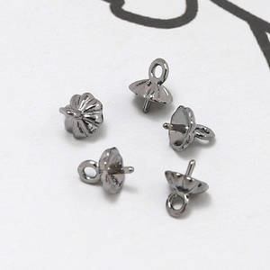 Macro-opname van vergulde parelkapjes met stift voor het maken van DIY-sieraden