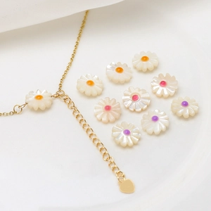 Detail of natural mother of pearl daisy charms and gold necklace for DIY jewelry making