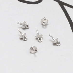 Macro-opname van verzilverde kraalkapjes met schroefdraadstiften voor doe-het-zelf sieraden