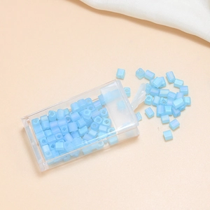 Detailed view of 4mm matte blue square glass beads in a clear organizer box for DIY jewelry
