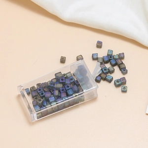 Macro detail of iridescent square glass seed beads with storage box for jewelry making