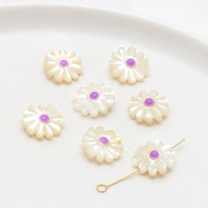 Macro detail of natural pearl daisy beads with purple centers and gold pin for DIY jewelry