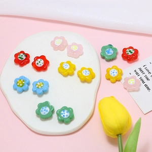 Colorful floral glass beads for DIY jewelry making displayed on a white textured tray