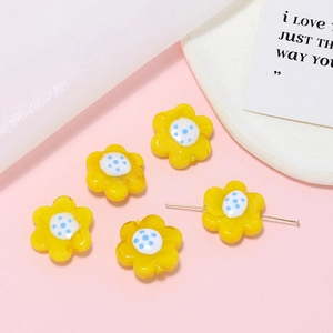 Macro view of five yellow glass flower beads for DIY jewelry making and bracelets