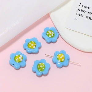 Detailed macro view of handmade blue glass flower beads with center holes for DIY jewelry