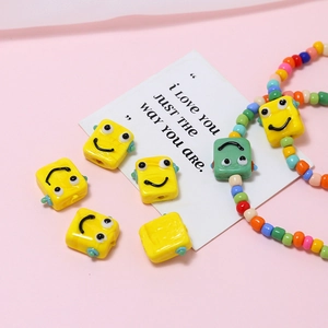 Detail von gelben und grünen Roboter-Smiley-Glasperlen für die DIY-Schmuckherstellung