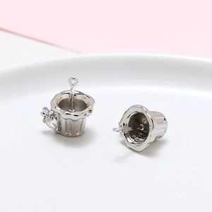 Détail de pendentifs en forme de coupe argentée avec textures et zircon incrusté