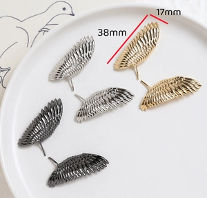 Vue macro de pendentifs ailes de 38mm x 17mm en finitions or, argent et noir fusil