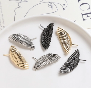 Vue détaillée de composants de bijoux en forme d'ailes en or argent et noir poli