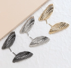 Vue détaillée de composants de boucles d'oreilles plume en finitions or, argent et noir