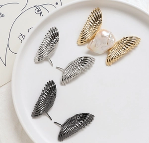 Vue détaillée du pendentif aile en perle baroque avec placage or, argent et noir
