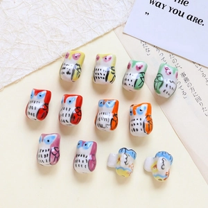 Macro shot of 12 colorful ceramic owl beads for DIY jewelry making and necklace crafts